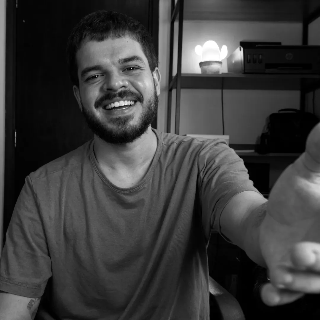 Uma foto do Mateus da Fly com a mão estendida e um sorriso no rosto, de forma bem simpática